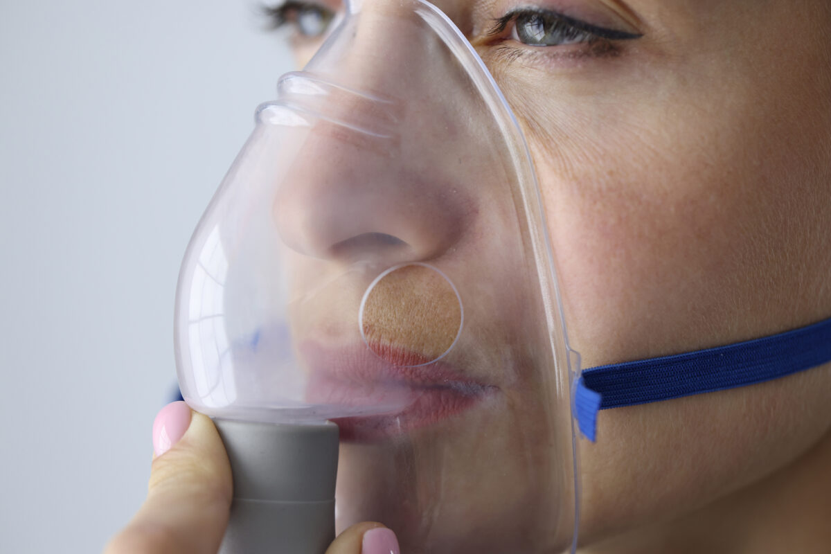 Portrait of woman breathing in oxygen mask closeup